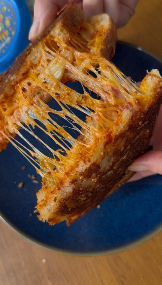 Toasted grilled cheese sandwich pulled apart with gooey melted cheese stretching between slices